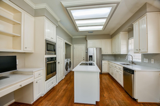 13702 Senca Park Dr, Houston, TX 77077 - kitchen with stainless steel appliances, washer and dryer, a sink, a center island, and white cabinetry