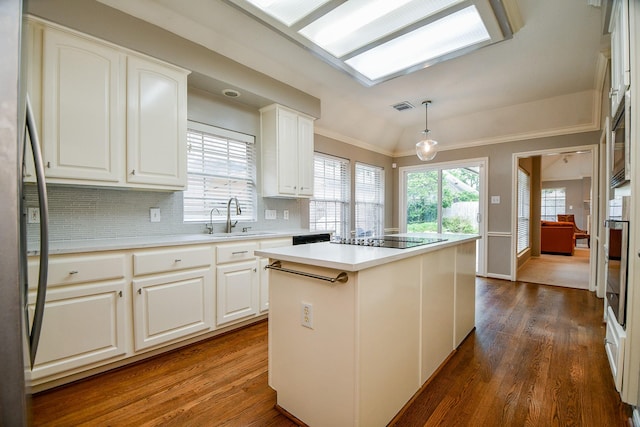 13702 Senca Park Dr, Houston, TX 77077 - kitchen with appliances with stainless steel finishes, dark wood-style floors, a sink, a center island, and vaulted ceiling