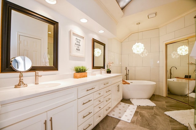 13702 Senca Park Dr, Houston, TX 77077 - full bathroom with lofted ceiling, double vanity, a freestanding bath, tile walls, and a chandelier