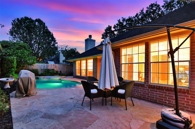 13702 Senca Park Dr, Houston, TX 77077 - pool at dusk featuring a patio area, fence, and outdoor dining area