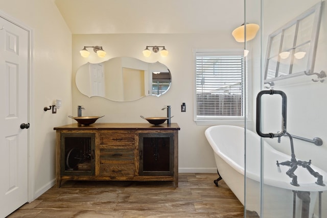 19030 Piney Way Dr, Tomball, TX 77375 - full bath with baseboards, a soaking tub, wood finished floors, and double vanity