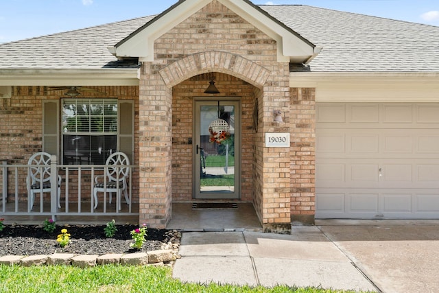 19030 Piney Way Dr, Tomball, TX 77375 - entrance to property featuring brick siding, roof with shingles, a garage, concrete driveway, and covered porch