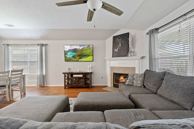 19030 Piney Way Dr, Tomball, TX 77375 - living room with ceiling fan, wood finished floors, a tile fireplace, vaulted ceiling, and baseboards