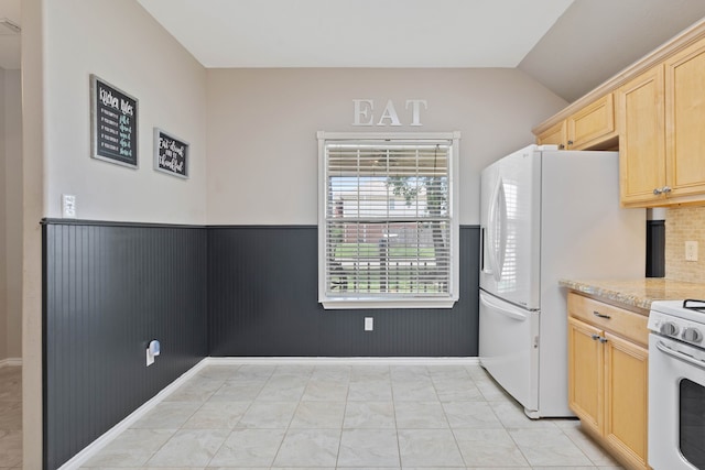 19030 Piney Way Dr, Tomball, TX 77375 - kitchen with a wainscoted wall, light brown cabinets, lofted ceiling, white appliances, and light stone countertops