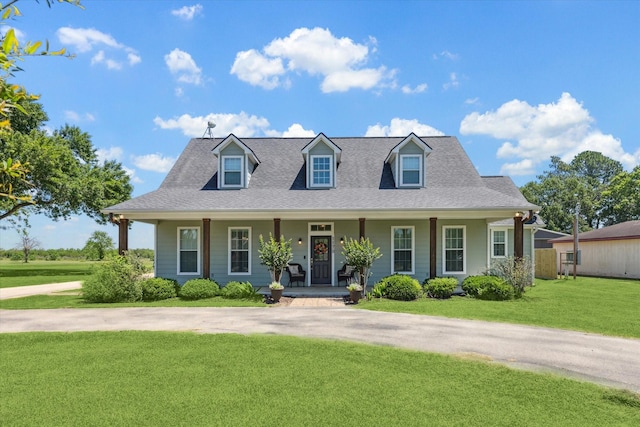 1170 Woody Ln, Sealy, TX 77474 - cape cod house with a front yard, covered porch, and roof with shingles