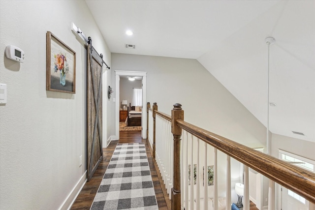 1170 Woody Ln, Sealy, TX 77474 - hallway with a barn door, dark wood-style flooring, an upstairs landing, lofted ceiling, and plenty of natural light