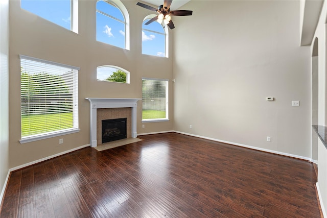 12314 Shore Lands Rd, Cypress, TX 77433 - unfurnished living room featuring a ceiling fan, a fireplace, hardwood / wood-style flooring, baseboards, and a high ceiling