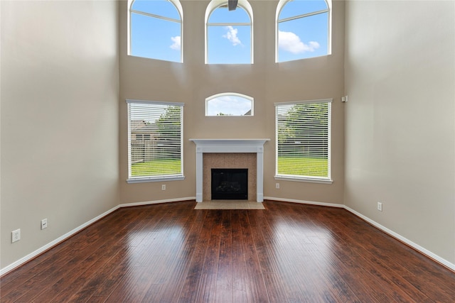 12314 Shore Lands Rd, Cypress, TX 77433 - unfurnished living room with hardwood / wood-style flooring, baseboards, a fireplace with flush hearth, and a high ceiling