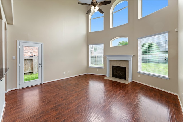 12314 Shore Lands Rd, Cypress, TX 77433 - unfurnished living room with a ceiling fan, a high ceiling, a fireplace with flush hearth, wood-type flooring, and baseboards