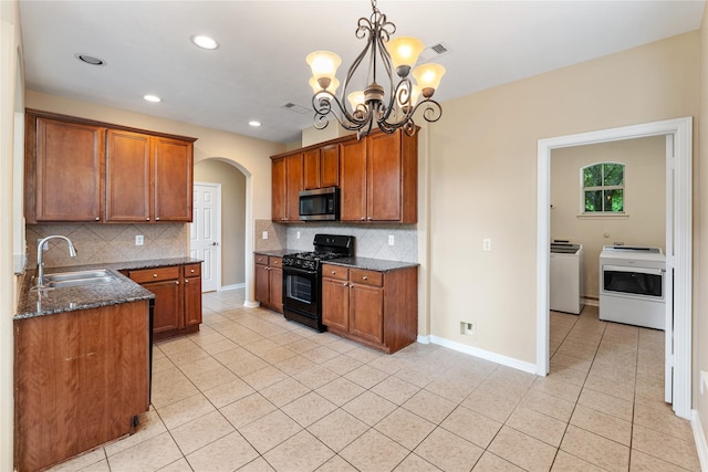 12314 Shore Lands Rd, Cypress, TX 77433 - kitchen with black gas stove, stainless steel microwave, a sink, arched walkways, and light tile patterned floors