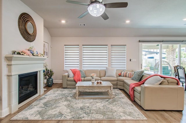 10014 Knollwood Ln, Missouri City, TX 77459 - living room with ceiling fan, recessed lighting, light wood-style floors, baseboards, and a glass covered fireplace