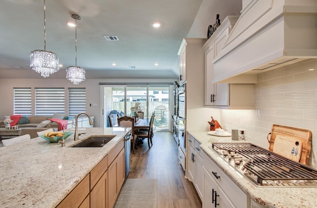 10014 Knollwood Ln, Missouri City, TX 77459 - kitchen featuring a sink, custom range hood, a chandelier, wood finished floors, and open floor plan