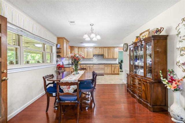 135 Sweetgum St, Trinity, TX 75862 - dining room featuring a chandelier, dark wood-type flooring, a textured ceiling, and baseboards