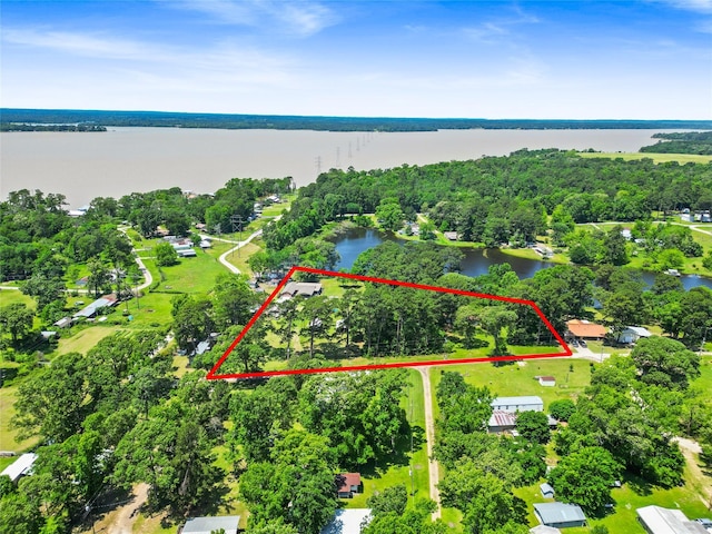 135 Sweetgum St, Trinity, TX 75862 - aerial view of property and surrounding area featuring a nearby body of water, property parcel outlined, and a tree filled landscape