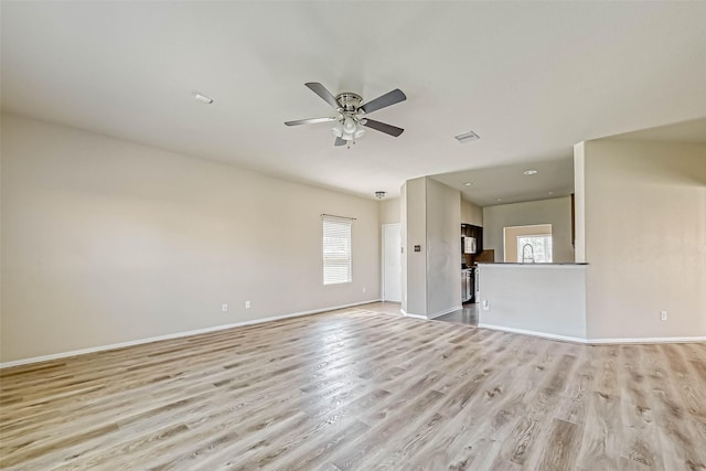 5006 Forest Hurst Gln, Spring, TX 77373 - unfurnished living room featuring plenty of natural light, light wood-type flooring, ceiling fan, baseboards, and recessed lighting