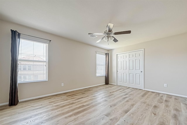 5006 Forest Hurst Gln, Spring, TX 77373 - unfurnished bedroom with multiple windows, light wood-style floors, baseboards, and a closet