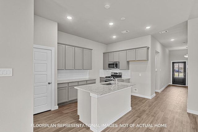 4981 Perennial Ln, La Marque, TX 77568 - kitchen featuring stainless steel appliances, gray cabinets, light wood finished floors, backsplash, and recessed lighting