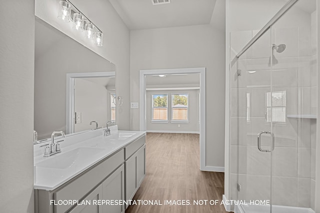 4981 Perennial Ln, La Marque, TX 77568 - bathroom with wood finished floors, a shower stall, double vanity, and baseboards