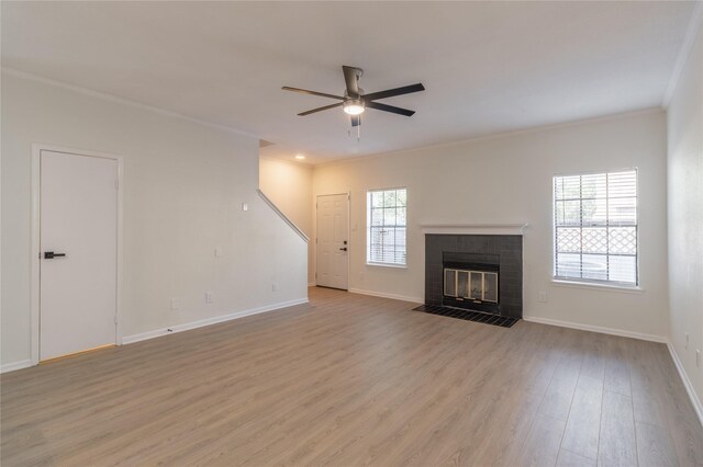 9850 Pagewood Ln Unit 909, Houston, TX 77042 - unfurnished living room featuring ornamental molding, ceiling fan, light wood-style flooring, baseboards, and a fireplace