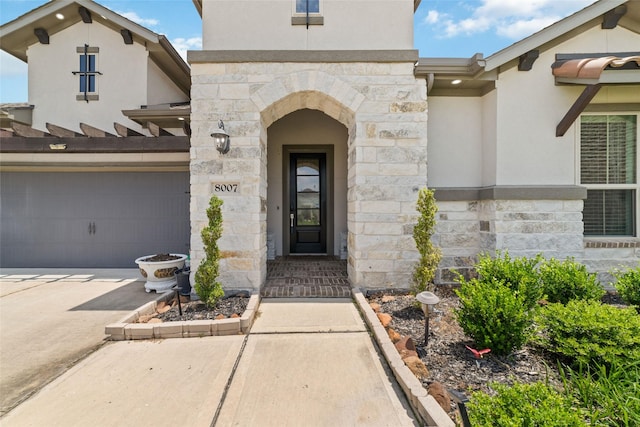 8007 Clearwater Glen Ct, Richmond, TX 77407 - doorway to property featuring stone siding, stucco siding, driveway, and a garage