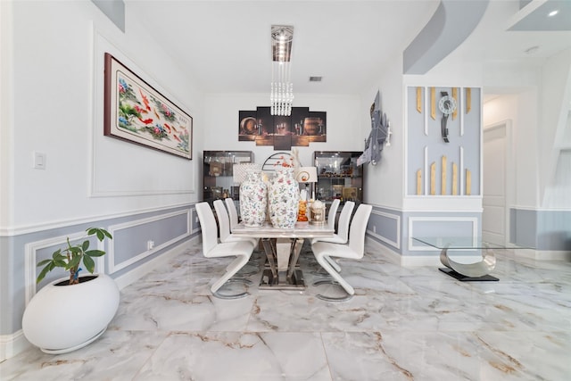 8007 Clearwater Glen Ct, Richmond, TX 77407 - dining area featuring a chandelier, marble tiled floors, a decorative wall, a wainscoted wall, and ornamental molding