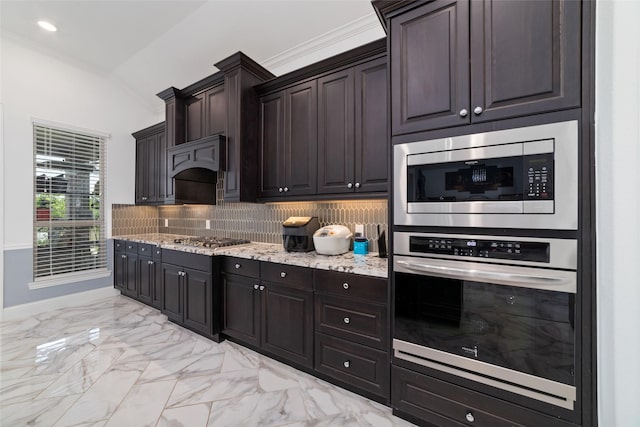8007 Clearwater Glen Ct, Richmond, TX 77407 - kitchen featuring appliances with stainless steel finishes, light marble finish flooring, lofted ceiling, tasteful backsplash, and light stone counters