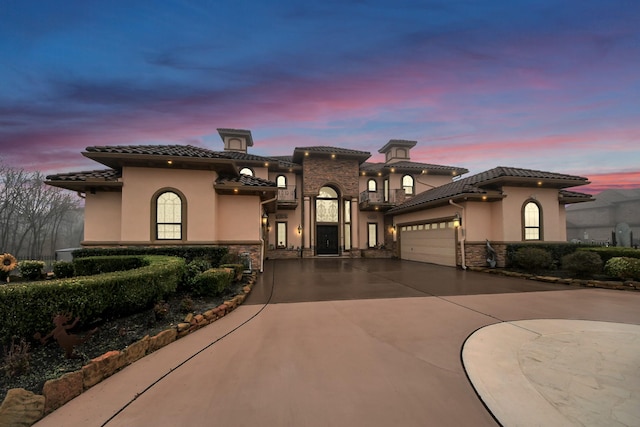 11503 Renaissance Dr, Montgomery, TX 77356 - mediterranean / spanish house featuring stone siding, a tiled roof, stucco siding, and a garage