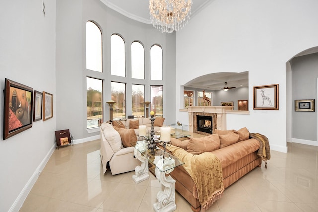 11503 Renaissance Dr, Montgomery, TX 77356 - living area with arched walkways, a towering ceiling, a high end fireplace, ceiling fan, and light tile patterned floors