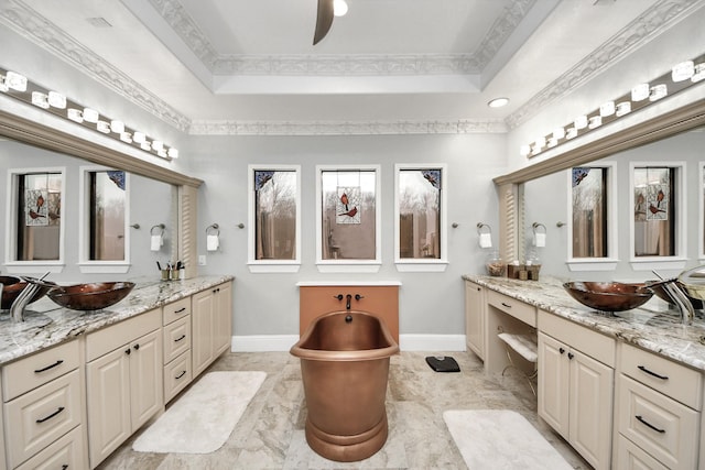 11503 Renaissance Dr, Montgomery, TX 77356 - bathroom with baseboards, a ceiling fan, a raised ceiling, crown molding, and two vanities