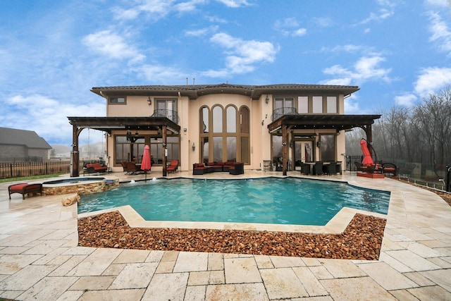 11503 Renaissance Dr, Montgomery, TX 77356 - back of house with a balcony, a patio area, an outdoor living space, stucco siding, and a pool with connected hot tub