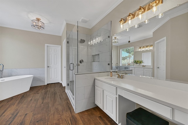 2833 Everett Dr, Friendswood, TX 77546 - bathroom featuring crown molding, a stall shower, vanity, a soaking tub, and wood finished floors