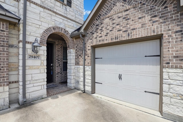 29407 Amber Meadows Ct, Katy, TX 77494 - view of exterior entry featuring stone siding, brick siding, an attached garage, and concrete driveway