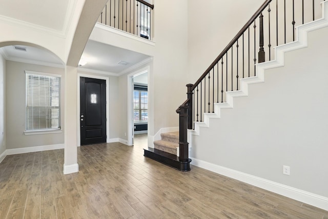 29407 Amber Meadows Ct, Katy, TX 77494 - foyer featuring arched walkways, wood finished floors, stairs, baseboards, and ornamental molding