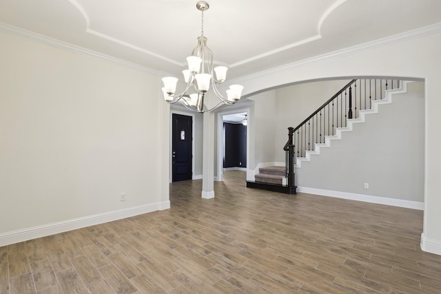29407 Amber Meadows Ct, Katy, TX 77494 - unfurnished dining area with a chandelier, stairway, a raised ceiling, wood finished floors, and ornamental molding
