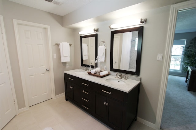 full bath with baseboards and double vanity