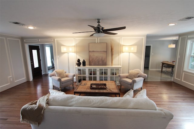 living area featuring a decorative wall, a ceiling fan, wood finished floors, recessed lighting, and baseboards