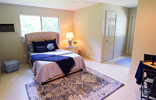 bedroom featuring a wall mounted AC and baseboards