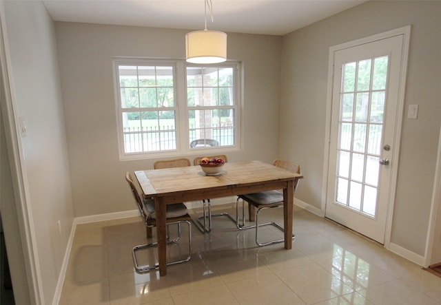 dining space with plenty of natural light, baseboards, and light tile patterned flooring