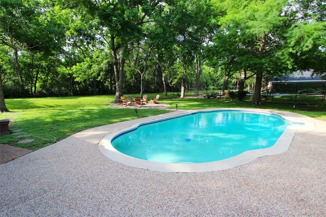 outdoor pool featuring view of scattered trees and a patio area
