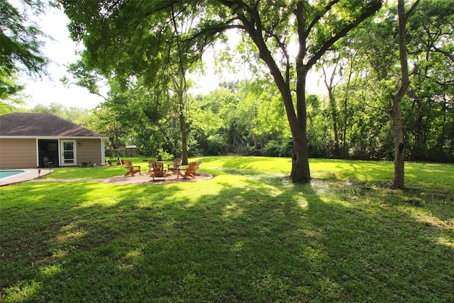 view of green lawn with a fire pit