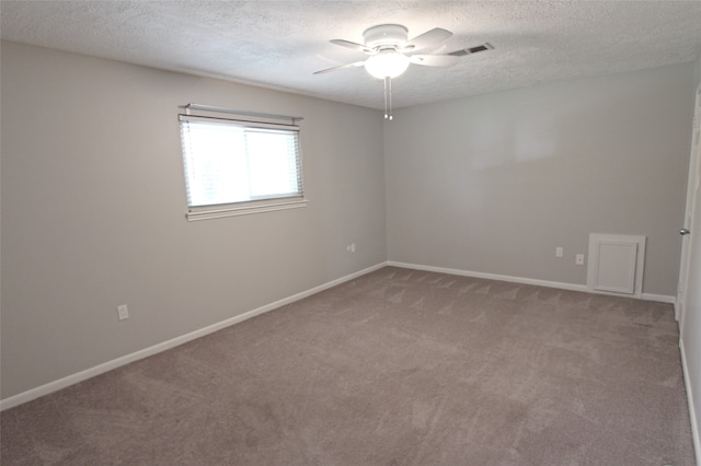 spare room featuring light carpet, ceiling fan, a textured ceiling, and baseboards