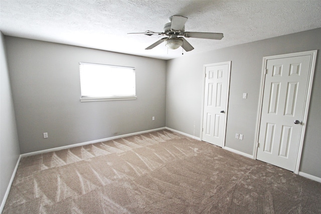 unfurnished bedroom featuring carpet, baseboards, a ceiling fan, and a textured ceiling