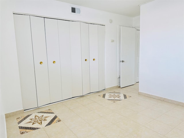 6405 Westward St Unit 96, Houston, TX 77081 - unfurnished bedroom with a closet, baseboards, and light tile patterned flooring