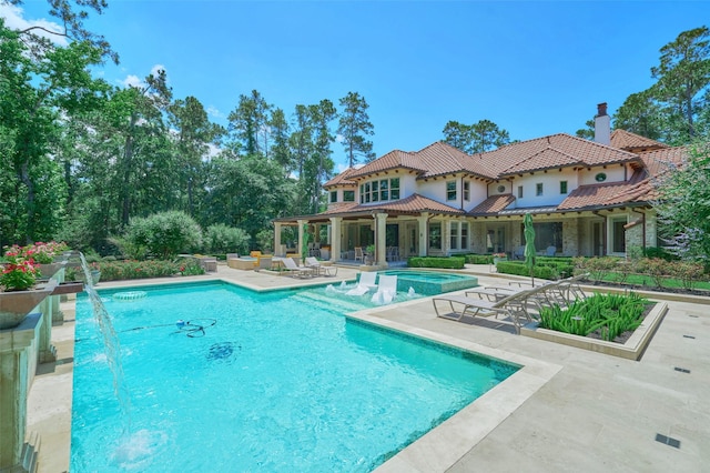 swimming pool featuring a hot tub and a patio