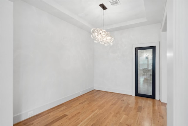 1221 Lamonte Ln, Houston, TX 77018 - spare room featuring wood finished floors, a raised ceiling, baseboards, and a chandelier