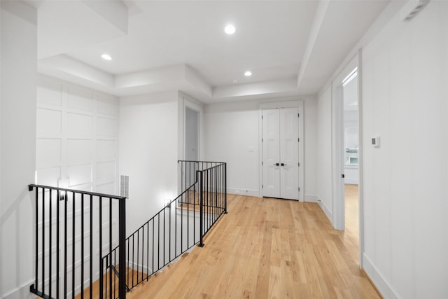 1221 Lamonte Ln, Houston, TX 77018 - corridor with an upstairs landing, a tray ceiling, light wood-style floors, recessed lighting, and baseboards
