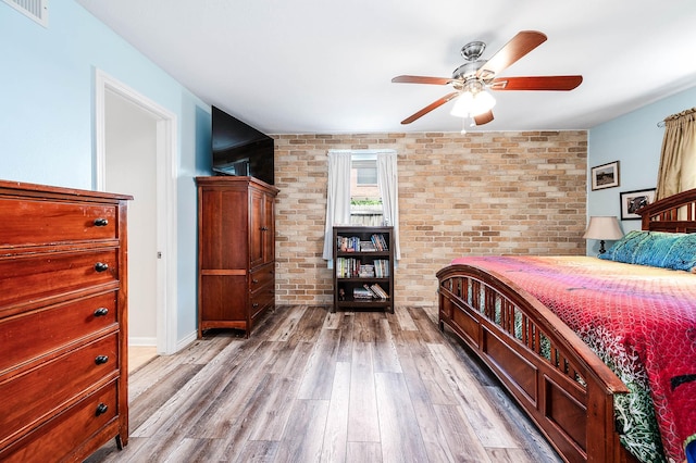 22331 Unicorns Horn Ln, Katy, TX 77449 - bedroom featuring brick wall, wood finished floors, and ceiling fan