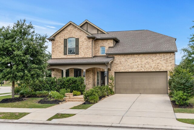 16114 Lake Amistad Pl, Cypress, TX 77433 - traditional-style home featuring a porch, a garage, driveway, brick siding, and roof with shingles