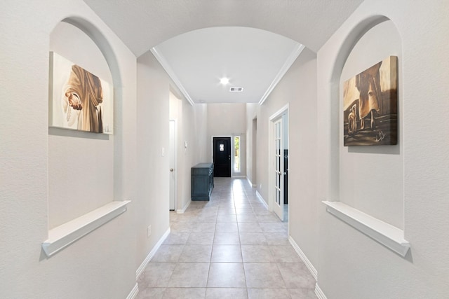 16114 Lake Amistad Pl, Cypress, TX 77433 - corridor with light tile patterned floors, baseboards, ornamental molding, and arched walkways