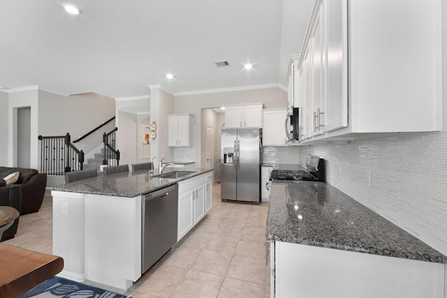 16114 Lake Amistad Pl, Cypress, TX 77433 - kitchen with appliances with stainless steel finishes, a sink, backsplash, white cabinets, and ornamental molding